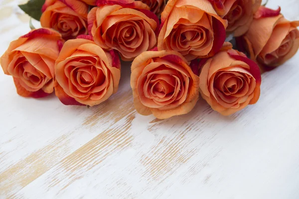 Orange roses on white rustic wooden background — Stock Photo, Image