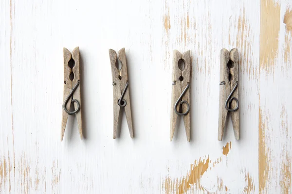 Quatro clothespins no fundo de madeira branco — Fotografia de Stock