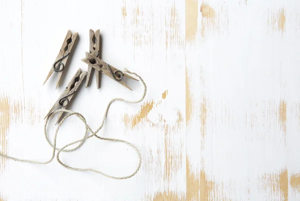 Верёвка для белья и прищепки на белом деревянном фоне — стоковое фото