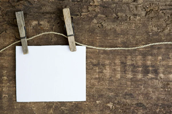 Beyaz kağıt bir clothesline üzerinde rustik ahşap arka plan asılı — Stok fotoğraf