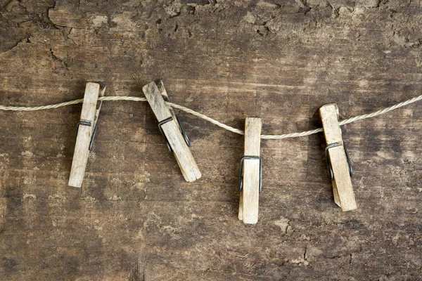 Верёвка для белья и прищепки на деревенском деревянном фоне — стоковое фото