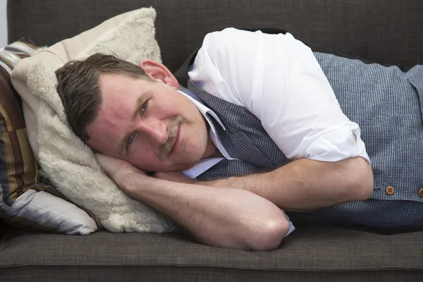 Hombre acostado en el sofá y sonriendo — Foto de Stock