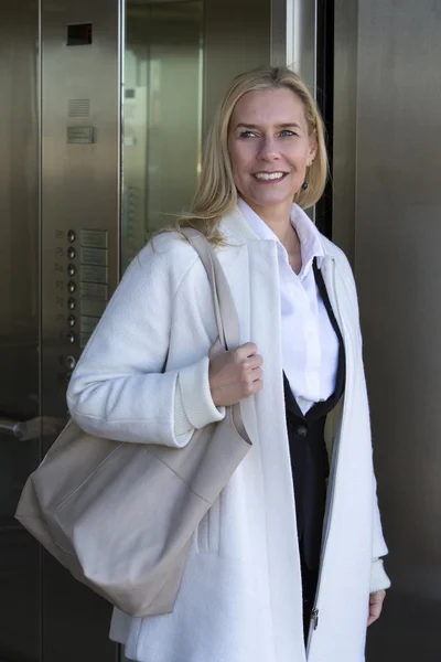 Woman coming out of an elevator — Stock Photo, Image