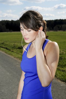 kulaklıklar ile egzersiz giysili genç kadın