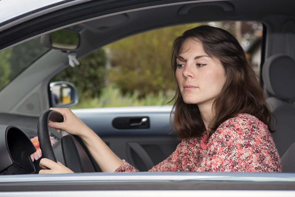 Jonge vrouw zittend in een auto — Stockfoto