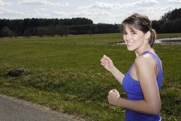 Ung kvinne som jogger utendørs – stockfoto
