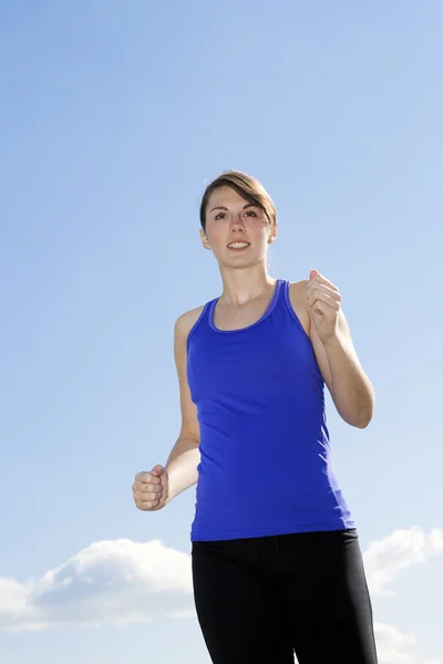Ung kvinne som jogger utendørs – stockfoto