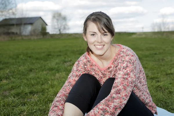 Jeune femme assise dehors sur l'herbe — Photo