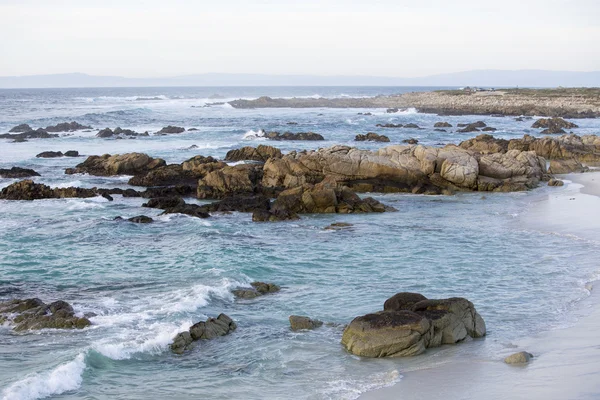 Sand beach with rocks and blue waves — Stock Photo, Image