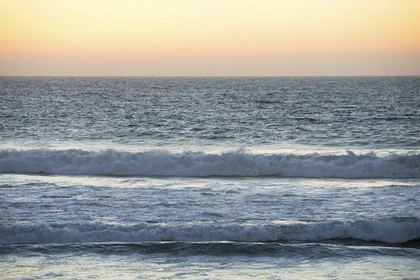 Waves on beach at sunset — Stock Photo, Image