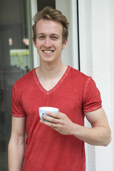 young blond man with a cup