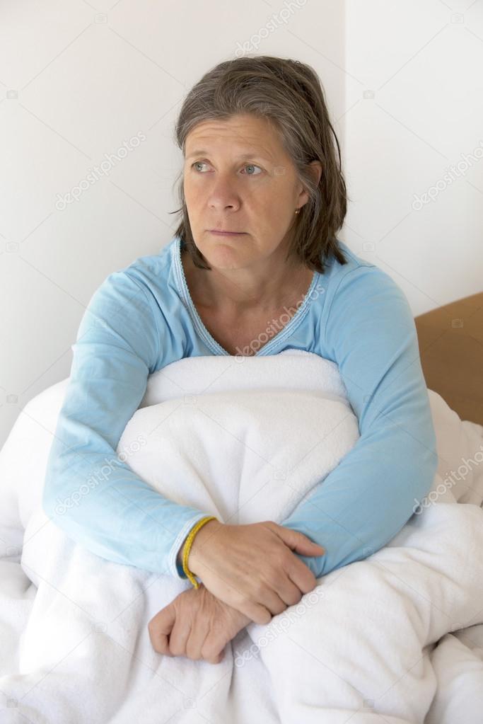 sad woman sitting in bed