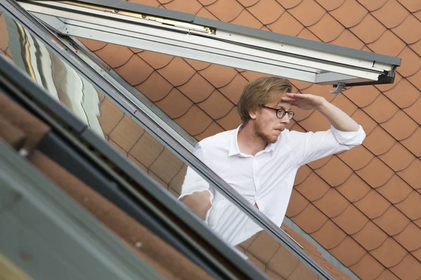 Joven mirando por una ventana de la azotea —  Fotos de Stock