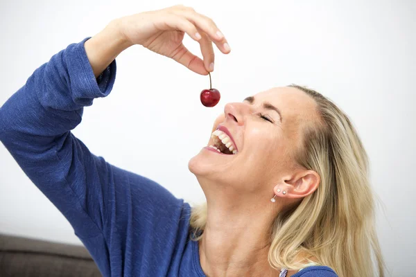 Mulher loira comendo uma cereja — Fotografia de Stock