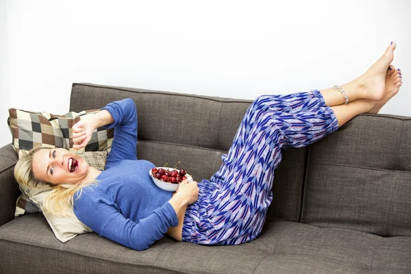 Mujer rubia comiendo cerezas — Foto de Stock