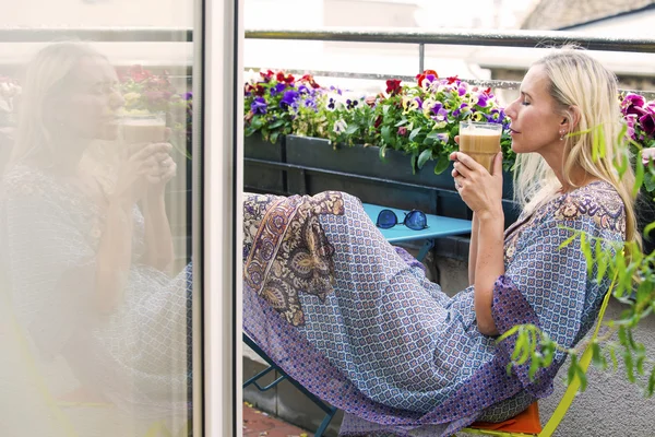 Mulher loira sentada na varanda com café — Fotografia de Stock