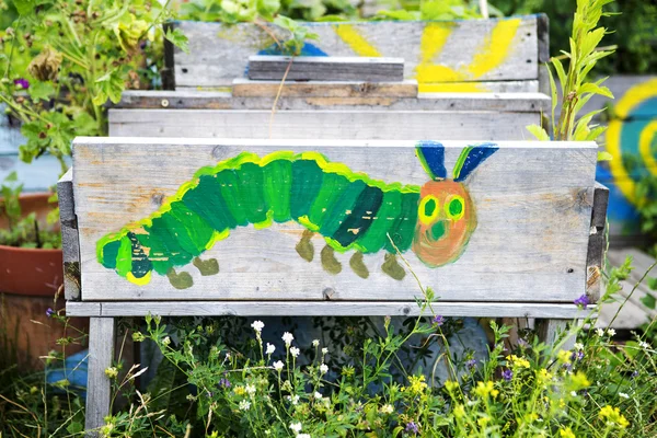 Bemalte Raupe auf Holzbrett im Garten — Stockfoto