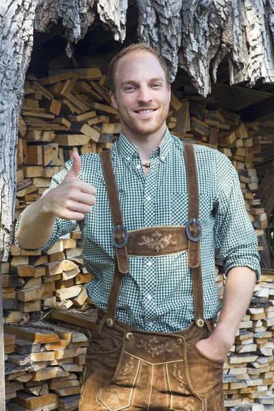 Young man in bavarian lederhosen with thumbs up — Stock Photo, Image