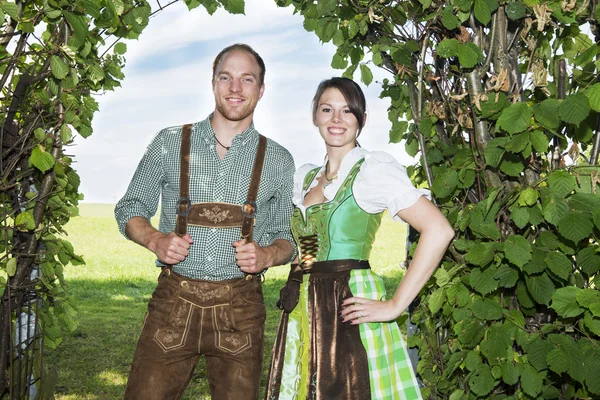 Bavarian couple standing underneath a tree — Stock Photo, Image