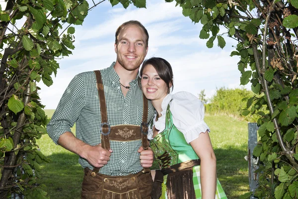 Bavarian couple standing underneath a tree — Stock Photo, Image