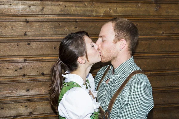 Pareja en tradicional bavarian ropa son besos —  Fotos de Stock