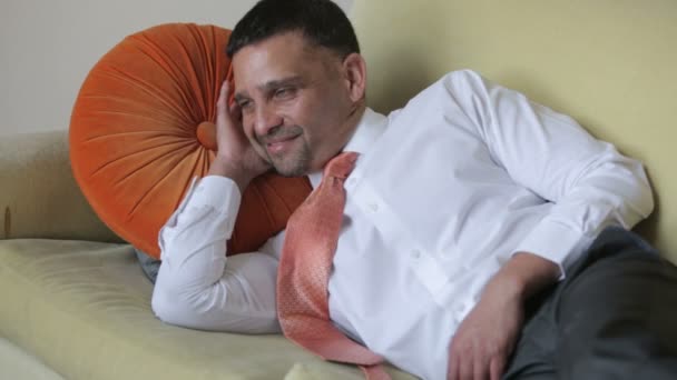 Hombre de negocios con camisa y corbata descansando y bostezando en un sofá — Vídeos de Stock