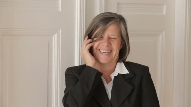 Businesswoman in her 50s talking on the phone and looks cheerful — Stock Video