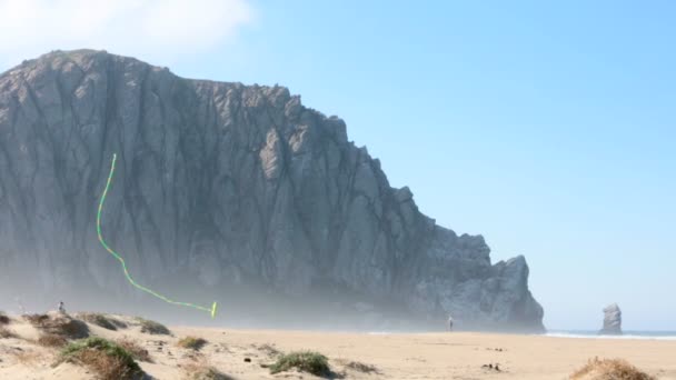 Big rock at Morro Bay and colorful kite in the blue sky — Stock Video