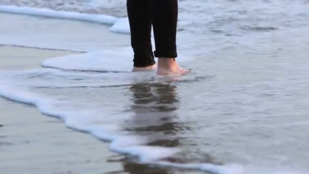 Крупным планом босых ног пожилой женщины, идущей вдоль пляжа — стоковое видео