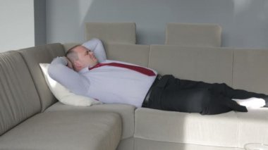 oturma odasında kanepede yatan ve uyumaya çalışıyor işadamı