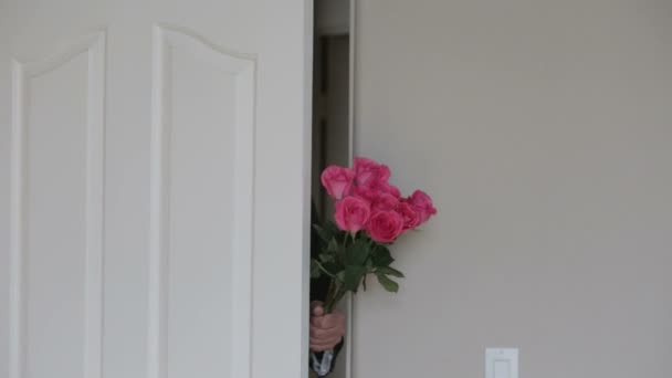 Homme en costume vient par la porte tenant un bouquet de roses — Video