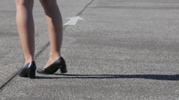 Legs of a businesswoman walking on the street and following an arrow — Stock Video