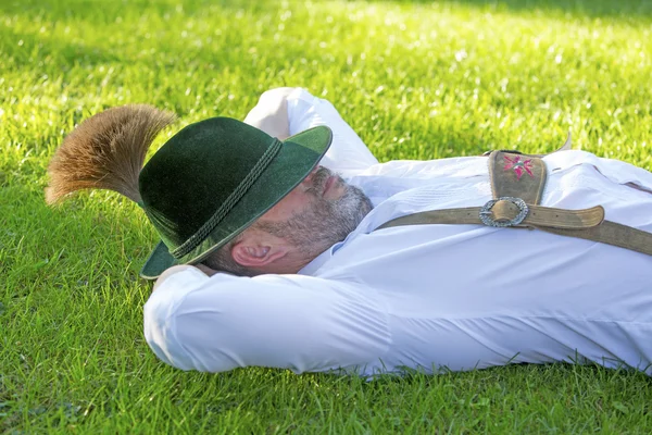 Bávaro homem dormindo na grama — Fotografia de Stock