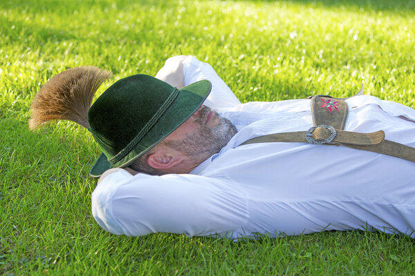bavarian man sleeping on the grass