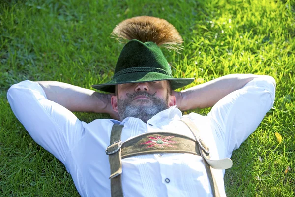 Bayerska man sova på gräset — Stockfoto