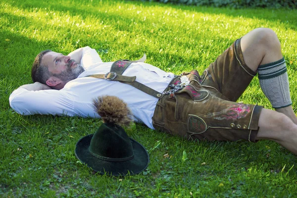 バイエルン男性は草の上に横たわる — ストック写真