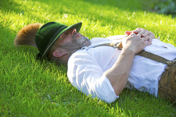 bavarian man sleeping on the grass