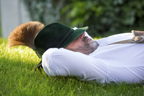 Bavarian man sleeping on the grass Stock Photo