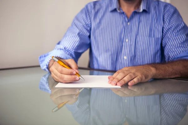 Primer plano del hombre escribiendo en un pedazo de papel — Foto de Stock