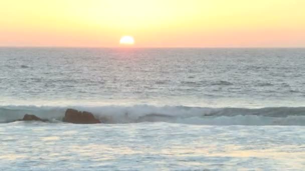 Olas azules y una puesta de sol en el horizonte — Vídeo de stock