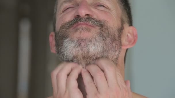 Knappe man krabben zijn jeukende baard — Stockvideo