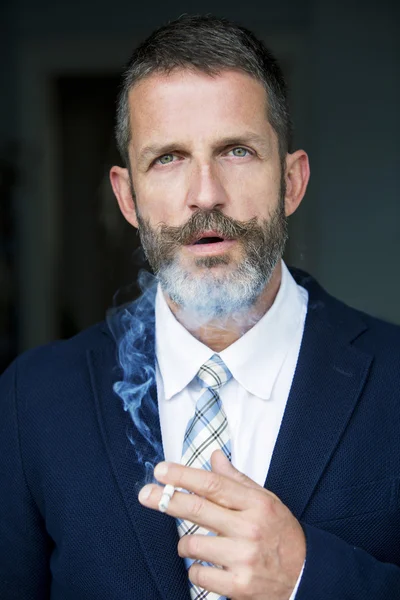 Portrait of businessman smoking a cigarette — Stock Photo, Image