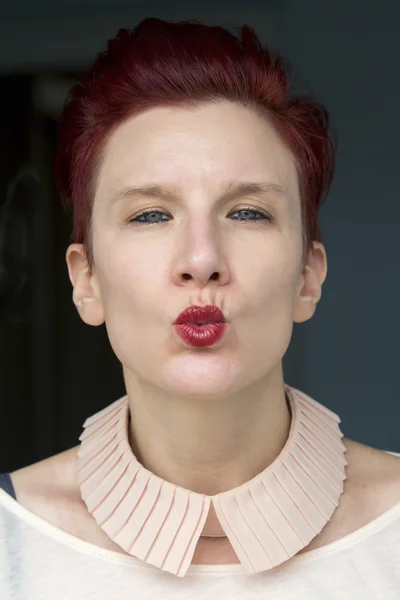 Portrait of red-haired woman giving a kiss — Stock Photo, Image