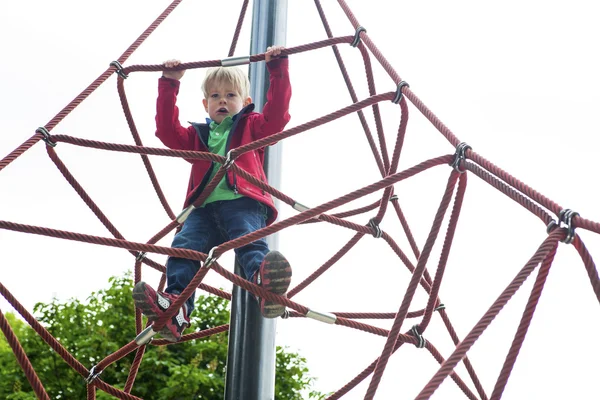 Garçon escalade sur aire de jeux — Photo