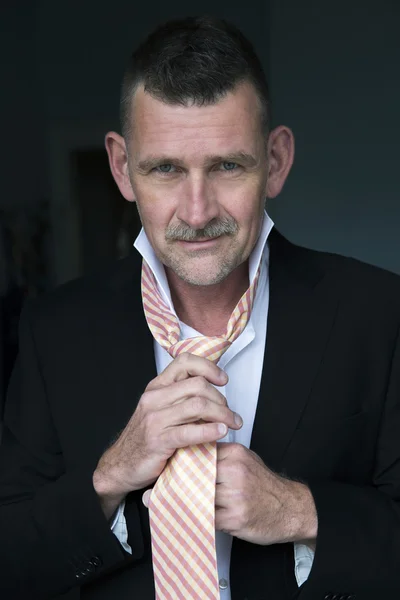 Hombre guapo atando su corbata — Foto de Stock