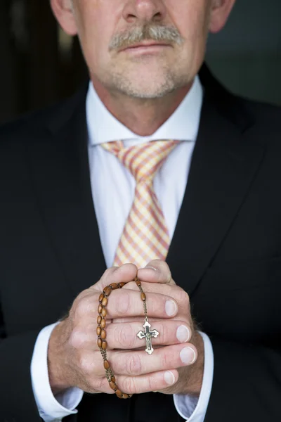 Businessman praying with rosary — Stock Photo, Image