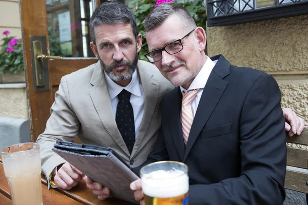 Two businessmen with tablet at a restaurant — Stock Photo, Image