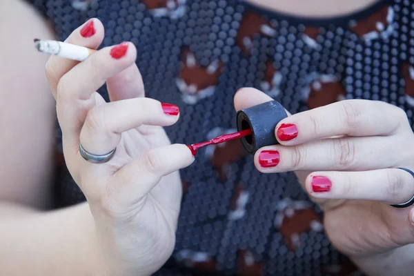 Primer plano de la mujer poniendo esmalte de uñas en — Foto de Stock