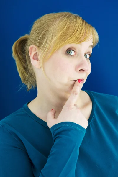 Portrét blondýnka drží prst na ústa — Stock fotografie