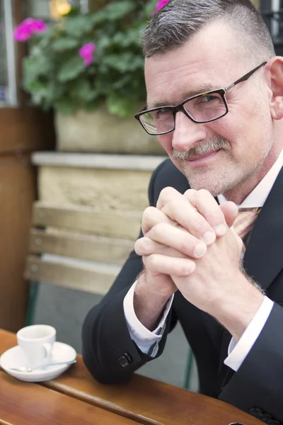 Mann sitzt draußen vor Restaurant mit Kaffee — Stockfoto